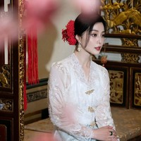 Penampilannya semakin anggun dengan sanggul menyamping yang dihias aksen bunga di rambut. Tak lupa lipstik merah yang jadi ciri khas riasannya. Foto: Instagram/@bingbing_fan