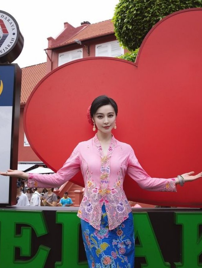 Fan Bingbing memadukan kebaya pink dengan kain batik peranakan warna biru terang motif bunga. Foto: Instagram/@bingbing_fan