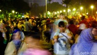 Selain menikmati wahana pasar malam, pengunjung lainnya piknik di taman Monas.