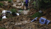 Petugas membersihkan makam yang tertimbun tanah longsor di Taman Pemakaman Umum (TPU) Sei Panas, Batam, Kepulauan Riau, Sabtu (22/6/2024).