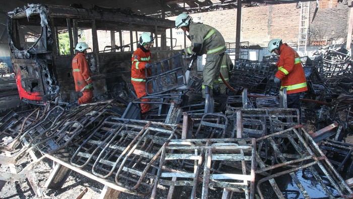 Dua anggota Polri dari Tim Inafis Polrestabes Surabaya melakukan olah tempat kejadian perkara (TKP) bengkel yang terbakar di Kantor Pemasaran dan Pool Damri Cabang Surabaya Jalan Jagir Wonokromo 306, Surabaya, Jawa Timur, Sabtu (22/6/2024). Olah TKP itu dilakukan sebagai proses penyelidikan atas terbakarnya bengkel Damri yang menghanguskan satu bus listrik, empat mobil dan dua sepeda motor. ANTARA FOTO/Didik Suhartono/nz