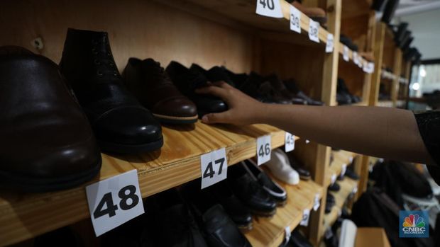 Pekerja menyelesaikan pembuatan pola alas kaki sepatu kulit di workshop Flavio Boston di kawasan Jakarta, Rabu (19/6/2024). (CNBC Indonesia/Tri Susilo)