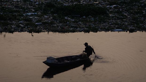 Warga menaiki perahu di dekat tumpukan sampah yang telah dijaring di aliran Sungai Citarum, Kabupaten Bandung Barat, Jawa Barat, Jumat (21/6/2024). Pemerintah Jawa Barat menerapkan jaring penyekat sampah di sejumlah titik dari hulu hingga hilir di aliran Sungai Citarum sebagai salah satu pilihan dalam mengatasi dan mengantisipasi sampah yang terbawa arus ataupun mengendap di aliran sungai. ANTARA FOTO/Novrian Arbi/aww.