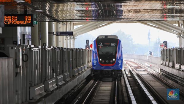 Penumpang menaiki LRT Jakarta saat melintas di kawasan Rawamangun, Jakarta, Sabtu (22/6/2024). (CNBC Indonesia/Faisal Rahman)