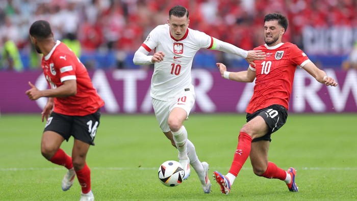 BERLIN, GERMANY - JUNE 21: Piotr Zielinski of Poland is challenged by Florian Grillitsch of Austria during the UEFA EURO 2024 group stage match between Poland and Austria at Olympiastadion on June 21, 2024 in Berlin, Germany. (Photo by Alex Livesey/Getty Images)