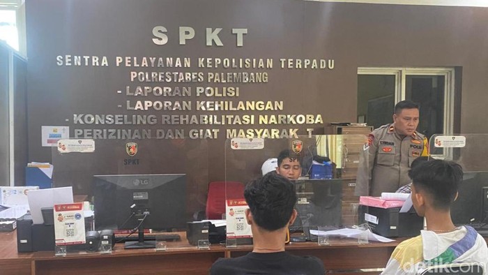 Rio (jaket putih) melapor ke SPKT Polrestabes Palembang usai dianiaya oleh ayah pacarnya, HM.