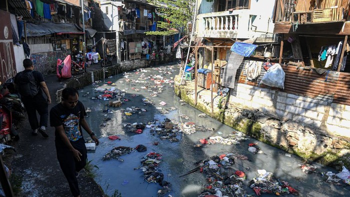 Hii..Jorok! Sungai CIliwung Kecil Dipenuhi Sampah Warga mengendong anaknya di pinggir aliran Sungai Ciliwung Kecil di kawasan Kebon Kacang, Tanah Abang, Jakarta, Minggu (23/6/2024). Menurut keterangan warga sungai yang membelah pusat kota Jakarta tersebut selalu dipenuhi sampah rumah tangga saat musim kemarau sehingga air tidak dapat mengalir dengan baik dan menimbulkan bau yang tidak sedap serta dapat menyebabkan penyakit gatal-gatal. ANTARA FOTO/Muhammad Adimaja/nym.