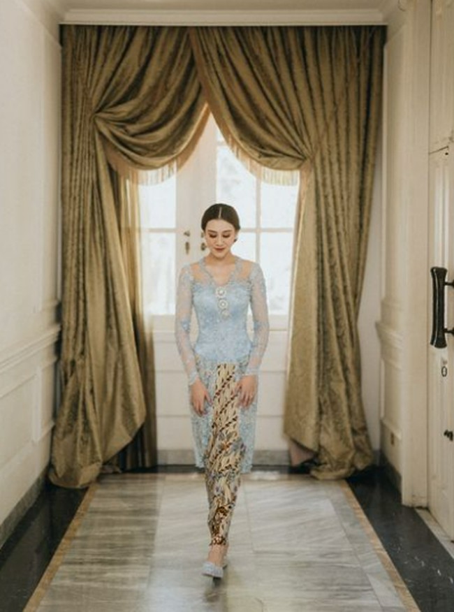 Aaliyah Massaid memilih gaya yang lembut dan klasik dengan kebaya biru pastel model kutu baru yang berpadu dengan kain batik motif parang. Siluet kebayanya ramping dengan detail lace halus, menonjolkan kesan feminin. Cocok sebagai inspirasi untuk lamaran dengan nuansa intimate dan tradisional. Foto: Instagram/@aaliyah.massaid @morden.co