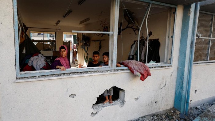 A Palestinian child looks out from a UNRWA school, after the air strike on a neighbouring house to the school in Khan Younis, in the southern Gaza Strip, June 21, 2024. REUTERS/Mohammed Salem
