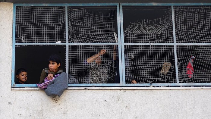 Keji! 21 Ribu Anak Hilang dalam Serangan Israel di Gaza A Palestinian child looks out from a UNRWA school, after the air strike on a neighbouring house to the school in Khan Younis, in the southern Gaza Strip, June 21, 2024. REUTERS/Mohammed Salem