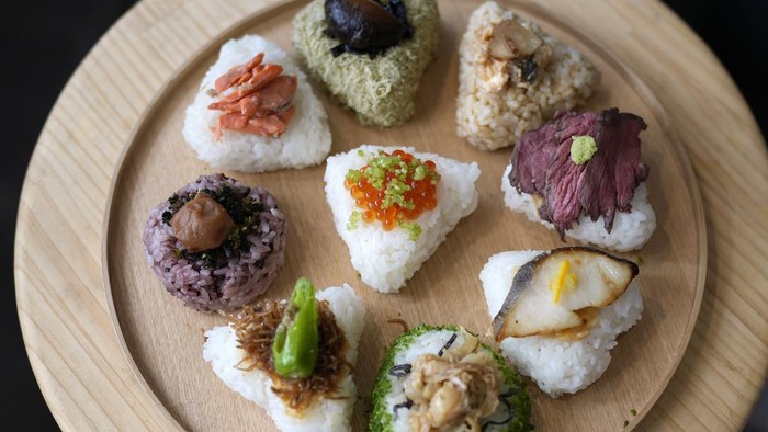 Kelezatan Onigiri Jepang yang Kini Masuk Kamus Bahasa Inggris Oxford Tourists from Australia eat onigiri, rice balls, at a Taro Tokyo Onigiri shop in Tokyo, on June 5, 2024. The word