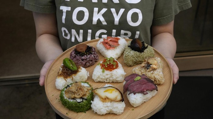 Kelezatan Onigiri Jepang yang Kini Masuk Kamus Bahasa Inggris Oxford Tourists from Australia eat onigiri, rice balls, at a Taro Tokyo Onigiri shop in Tokyo, on June 5, 2024. The word