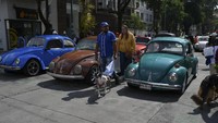 Orang-orang berjalan melewati Volkswagen Beetle antik, yang dikenal di Meksiko sebagai vocho di Mexico City, Meksiko, Sabtu (22/6/2024).