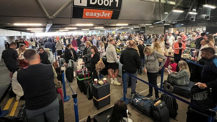 Potret Kacau Bandara Manchester Inggris gegara Mati Listrik Passengers queue outside Terminal 1 after an overnight power cut led to disruptions and cancellations at Manchester Airport in Manchester, Britain, June 23, 2024. REUTERS/Phil Noble