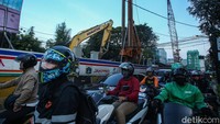 Kini proyek yang memasuki tahap pemasangan girder penopang jalur perlintasaan ini tengah dikebut, jalan yang menjadi sempit membuat kendaraan harus rela terkena macet.