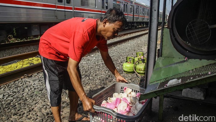 Potret Perajin Kerupuk di Pinggir Rel Jakarta Pekerja menggoreng kerupuk di industri kerupuk rumahan di Kebayoran Lama, Jakarta Selatan, Senin (24/6/2024). Dalam sehari usaha kecil milik Paiyem tersebut mampu memproduksi sekitar 1,5 hingga 2 kuintal kerupuk dan dijual eceran dengan harga Rp 5.000/plastik.