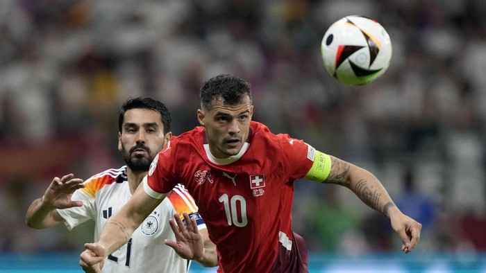 Switzerlands Granit Xhaka, right, fight for the ball with Germanys Ilkay Gundogan during a Group A match between Switzerland and Germany at the Euro 2024 soccer tournament in Frankfurt, Germany, Sunday, June 23, 2024. (AP Photo/Martin Meissner)