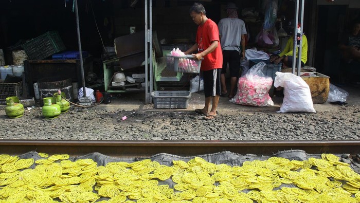 Usaha kerupuk rumahan di Jakarta Pekerja mengangkat kerupuk mentah yang telah kering usai dijemur di industri kerupuk rumahan kawasan Kebayoran Lama, Jakarta, Senin (24/6/2024). Menurut pedagang dalam sehari mereka dapat memproduksi dua hingga tiga kuintal berbagai jenis kerupuk untuk didistribusikan ke pasar di Jakarta yang diambil pedagang keliling. ANTARA FOTO/Reno Esnir/wpa/Spt.
