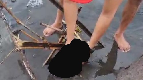 Warga mengangkat mayat bayi dari posisi awal ditemukan, lalu dipindahkan ke tempat kering di Pantai Cucukan, Gianyar, Senin (24/6/2024). (Dok pribadi Join Hermanto)