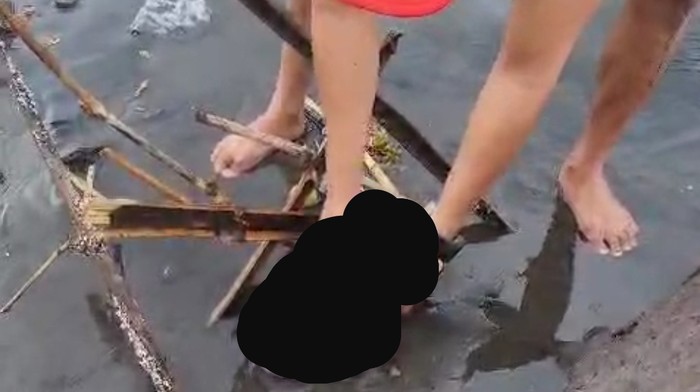 Warga mengangkat mayat bayi dari posisi awal ditemukan, lalu dipindahkan ke tempat kering di Pantai Cucukan, Gianyar, Senin (24/6/2024). (Dok pribadi Join Hermanto)