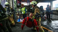 Beberapa petugas unjuk gigi dalam melakukan evakuasi korban dari atas gedung yang terbakar.