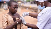 Seorang petugas kesehatan memberikan vaksin kanker serviks HPV Gardasil kepada seorang gadis di jalan di Ibadan, Nigeria.  