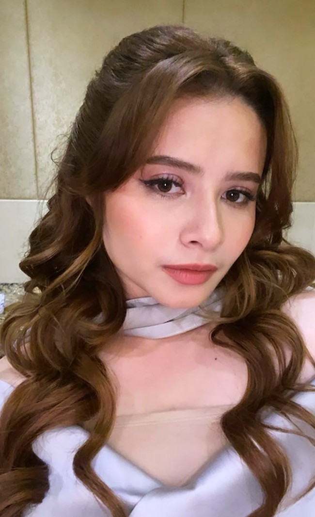 Jovita Karen membuat gaun berkerah sabrina yang anggun dan feminin. Padukan dengan tatanan rambut bergelombang yang diurai panjang. Foto: Instagram @jovitakaren