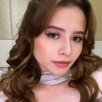 Jovita Karen membuat gaun berkerah sabrina yang anggun dan feminin. Padukan dengan tatanan rambut bergelombang yang diurai panjang. Foto: Instagram @jovitakaren