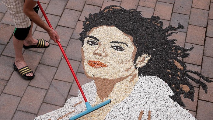 Kosovo artist Alkent Pozhegu works on a mosaic made of grains showing a portrait of Michael Jackson on the 15th anniversary of his death in Gjakova, Kosovo June 25, 2024. REUTERS/Valdrin Xhemaj