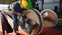Petugas melakukan pemeliharaan roda kereta api Minangkabau Ekspress.