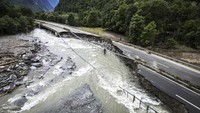Jalan raya A13 antara Lostallo dan Soazza terlihat hancur imbas meluapnya sungai Moesa akibat hujan lebat di lembah Misox, di Lostallo, Swiss selatan, Minggu (23/6).