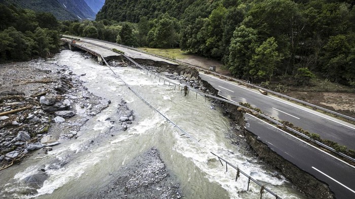 Penampakan Jalan Raya di Swiss Hancur Diterjang Banjir The highway A13 between Lostallo and Soazza is seen destroyed by the force of the Moesa river, caused by heavy rain in the Misox valley, in Lostallo, southern Switzerland, Sunday, June 23, 2024. Massive thunderstorms and rainfall led to a flooding situation on Friday evening after a landslide in the Misox valley. Four people went missing on Saturday morning. Several dozen people had to be evacuated from their homes in the Misox and Calanca regions. (Michael Buholzer/Keystone via AP)