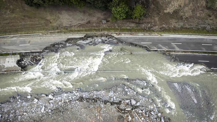 Penampakan Jalan Raya di Swiss Hancur Diterjang Banjir The highway A13 between Lostallo and Soazza is seen destroyed by the force of the Moesa river, caused by heavy rain in the Misox valley, in Lostallo, southern Switzerland, Sunday, June 23, 2024. Massive thunderstorms and rainfall led to a flooding situation on Friday evening after a landslide in the Misox valley. Four people went missing on Saturday morning. Several dozen people had to be evacuated from their homes in the Misox and Calanca regions. (Michael Buholzer/Keystone via AP)