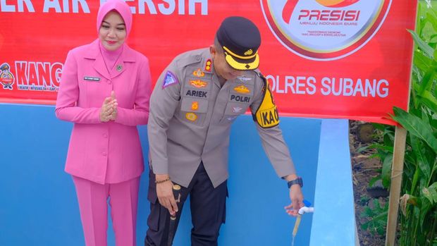 Polisi saat memberikan bantuan sumur bor dan pompa air bersih di Subang