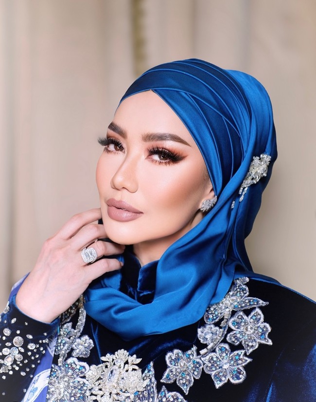 Kebaya yang dikenakan Reza dipadukan dengan kain batik berwarna biru dan selendang yang senada. Penampilannya itu kian menawan dengan hijab berbahan metallic. Foto: Instagram/@rezaartameviaofficial