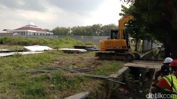 Alat berat backhoe dan pekerja diturunkan di lahan rumah hadiah negara untuk Jokowi di Jalan Adi Sucipto, Blulukan, Karanganyar, Selasa (25/6/2024).