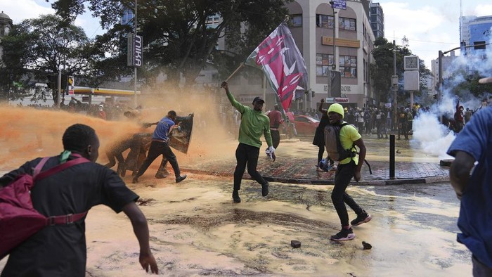 Demo Tolak Kenaikan Pajak di Kenya Chaos, 13 Orang Tewas Protesters scatter as Kenya police spray a water canon at them during a protest over proposed tax hikes in a finance bill in downtown Nairobi, Kenya Tuesday, June. 25, 2024. (AP Photo/Brian Inganga)
