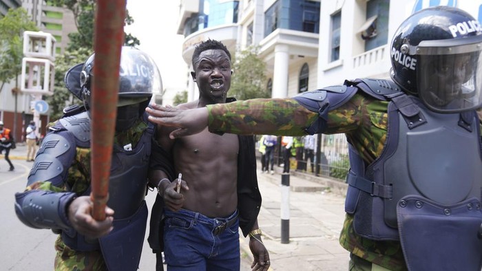 Protesters scatter as Kenya police spray a water canon at them during a protest over proposed tax hikes in a finance bill in downtown Nairobi, Kenya Tuesday, June. 25, 2024. (AP Photo/Brian Inganga)