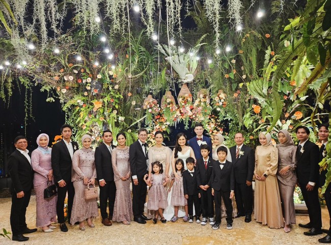 Berbeda dengan akad, di mana pengantin mengenakan pakaian adat Sunda, untuk resepsi malam hari keduanya tampil lebih santai dengan gaun putih dan setelan jas berwarna biru tua. Foto: Instagram/@drboykediannugraha
