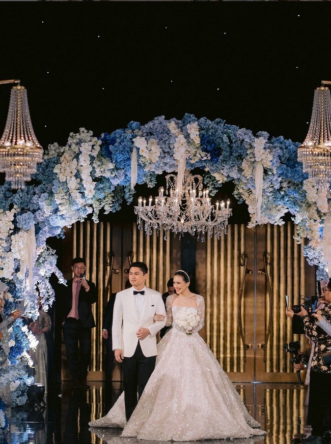 Suami Beby, Rizki Natakusumah, pun tampil istimewa. Anggota DPR ini mengenakan busana formal berupa setelan jas hitam putih dengan dasi kupu-kupu dari koleksi Wong Hang Tailor. Foto: Instagram/@bebytsabina @venemapictures