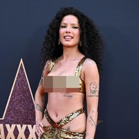 Pelantun lagu ‘New Americana’ ini menambah kesan glamor pada penampilannya dengan tatanan rambut keriting mengembang. Foto: Gilbert Flores/ Variety via Getty Images