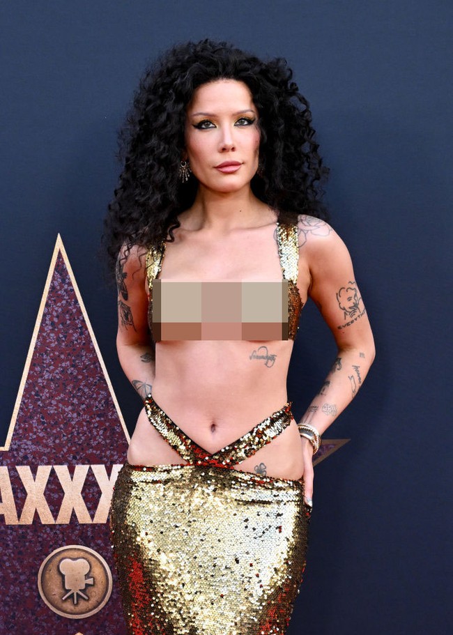 Busana bling-bling itu memperlihatkan perutnya yang ramping dan rata, serta beberpa tato di tulang rusuk dan area pelvis. Foto: Gilbert Flores/ Variety via Getty Images