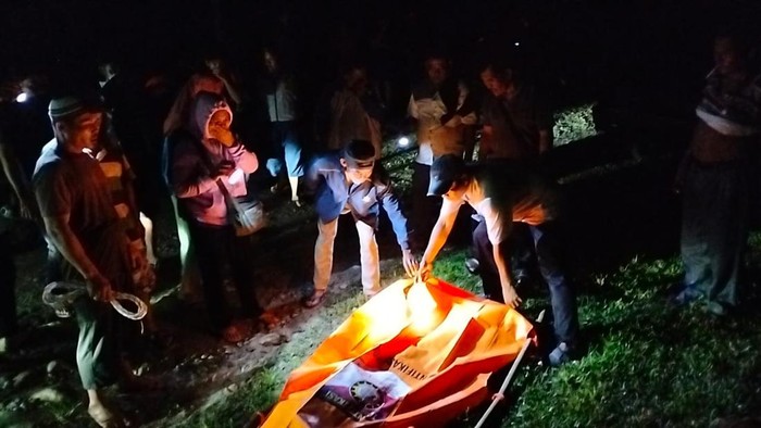 Petugas saat mengevakuasi jasad korban.