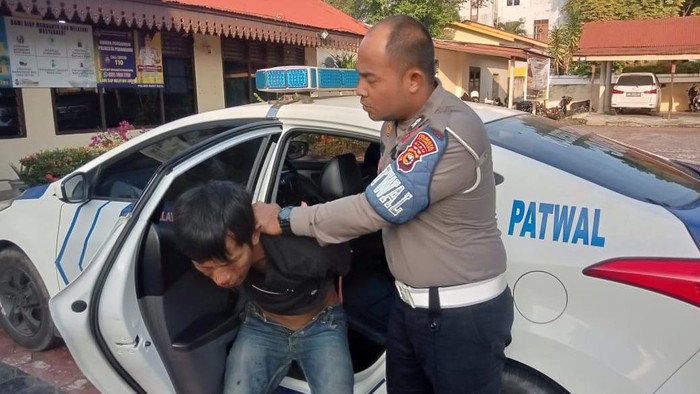 Polantas saat mengamankan pelaku. (Dok Satlantas)