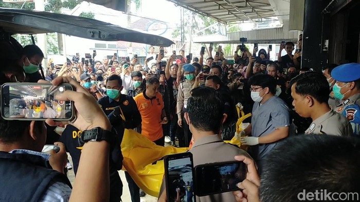 Polisi evakuasi jenazah petugas koperasi di belakang distro di Palembang.