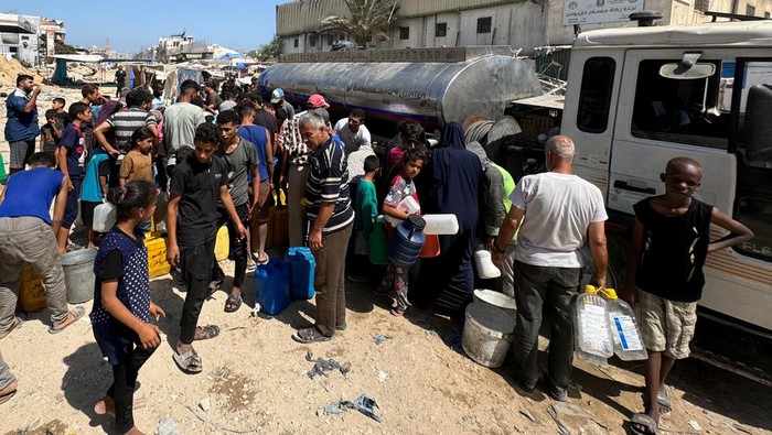 Bencana Kelaparan Kian Nyata, Warga Gaza Kesulitan Dapat Makan dan Air Palestinians gather to receive food cooked by a charity kitchen, amid food scarcity, as Israel-Hamas conflict continues, in Khan Younis in the southern Gaza Strip, June 26, 2024. REUTERS/Mohammed Salem