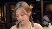 Nongkrong di kafe, Frislly memesan es teh lychee yang tampak menyegarkan. Ia pun berpose candid seperti ini. Foto: Instagram itsme.frisllyherlind