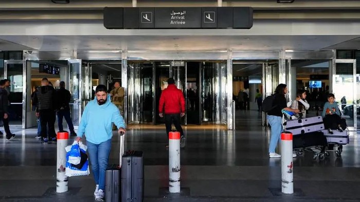 Travelers push their luggage as they leave the Rafik Hariri International Airport in Beirut, Lebanon, Monday, Jan. 8, 2024. (AP)