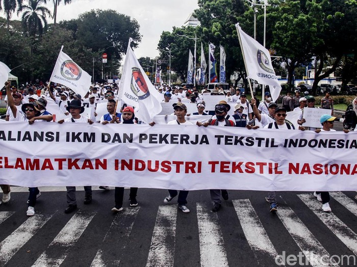 Massa dari Aliansi Industri Kecil Menengah (IKM) dan Pekerja Tekstil Indonesia menggelar aksi di kawasan Patung Kuda, Jakarta, Kamis (27/6/2024). Aksi tersebut untuk memprotes banyaknya pabrik tekstil yang gulung tikar hingga membuat para pekerja kehilangan pekerjaan karena kebijakan impor yang tidak sehat. Mereka menuntut pemerintah berpihak kepada produk dalam negeri dan menolak segala bentuk intervensi negara asing terhadap kebijakan pasar domestik.