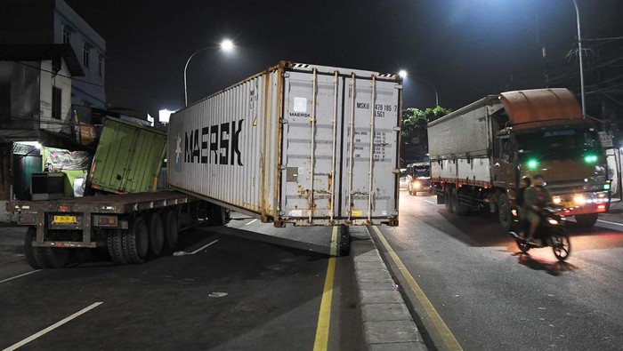 Kendaraan melintas di samping truk yang mengalami kecelakaan di Jalan Sultan Agung, Bekasi, Jawa Barat, Kamis (27/6/2024). Kecelakaan yang melibatkan dua mobil truk kontainer itu mengakibatkan sebuah pagar bengkel las rusak, tidak ada korban jiwa pada kejadian tersebut. ANTARA FOTO/ Fakhri Hermansyah/Spt.